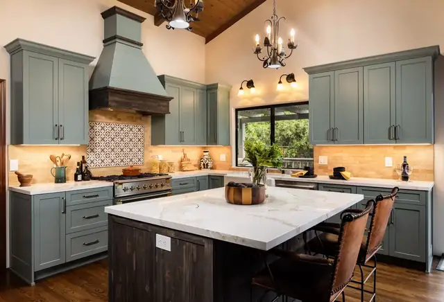 Vaulted Santa Barbara kitchen with blue-gray cabinets, hooded range, patterned tile backsplash and dark wood island