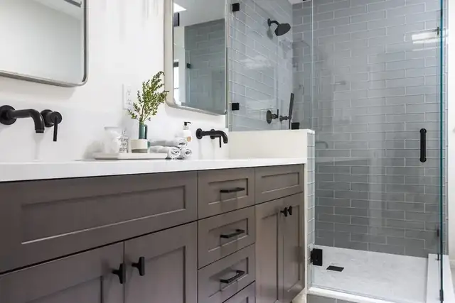 Santa Barbara bathroom remodel with charcoal gray vanity, white counter, matte black wall faucets and frameless glass shower with gray subway tile