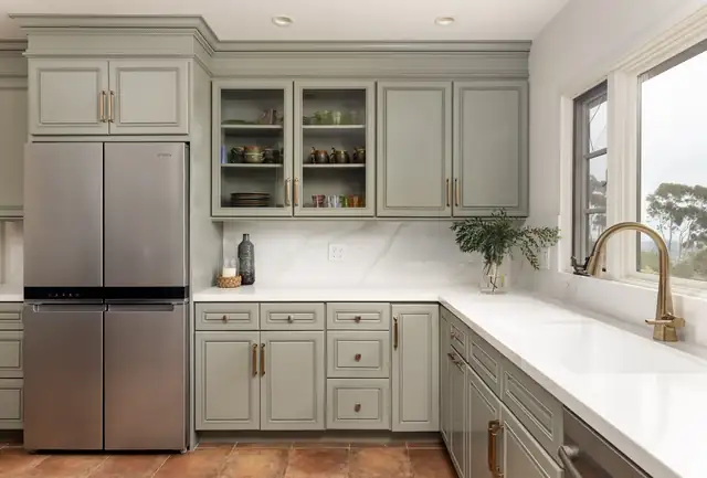 Santa Barbara Riviera kitchen with sage green shaker cabinets, white counters and brass faucet