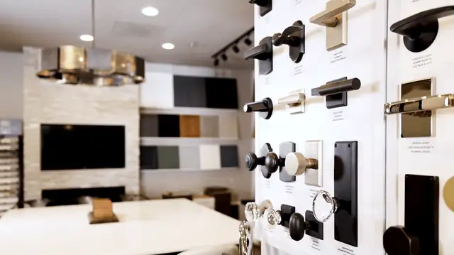 ELITE Remodels showroom with a cabinet hardware display wall, finish samples and a design table
